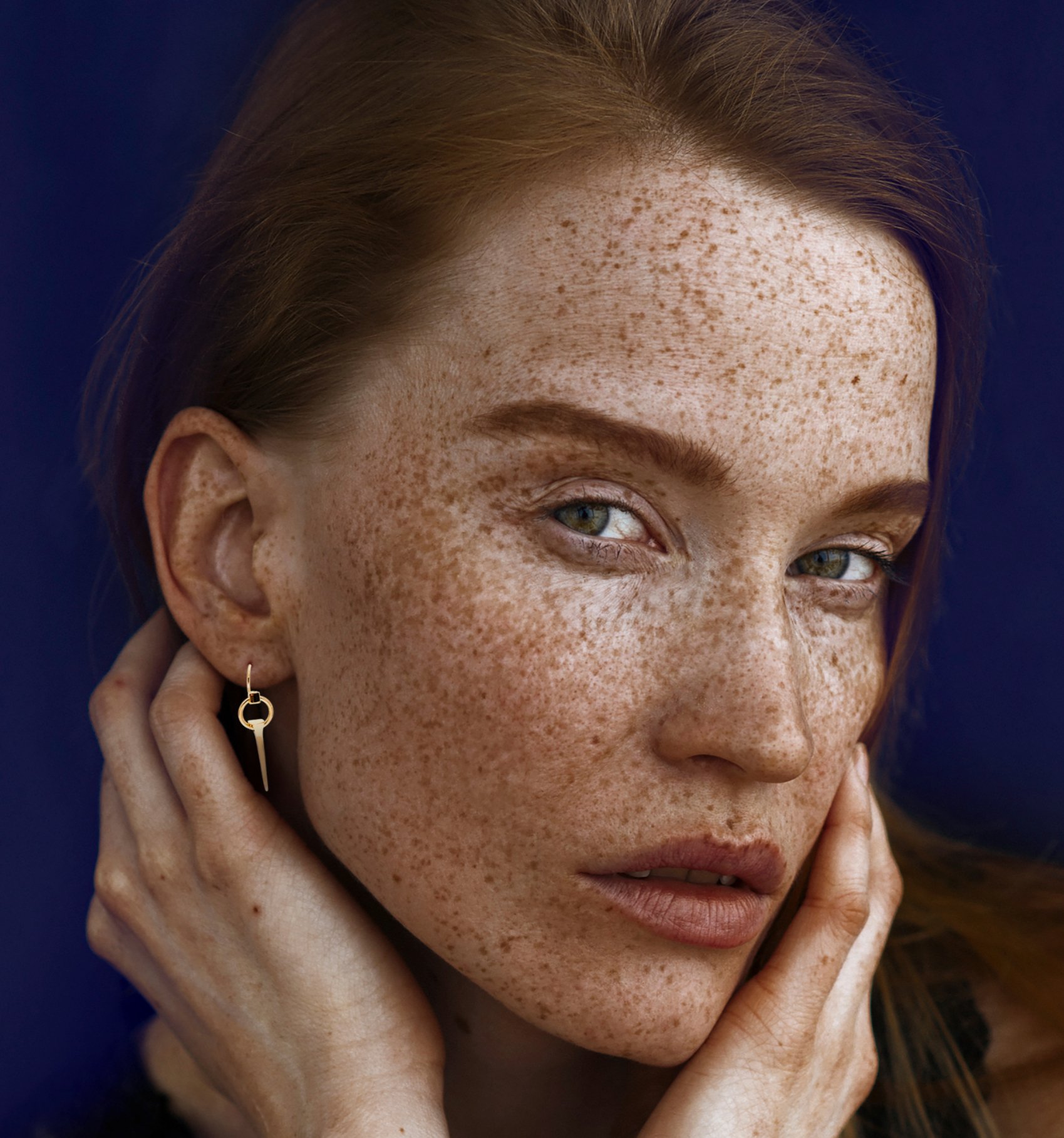 Freckled face reflecting silent trauma
